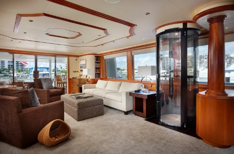Round pneumatic vacuum elevator installed in a luxury yacht salon with wood columns and ocean view