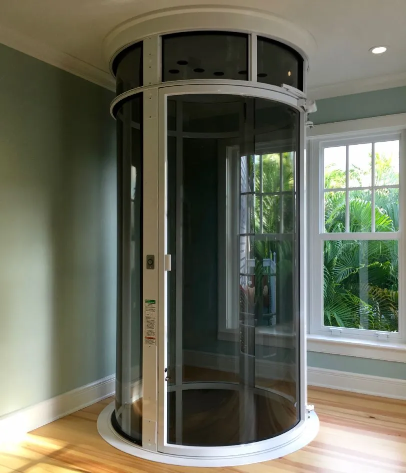 PVE52 round glass pneumatic vacuum elevator installed in a home corner with large window
