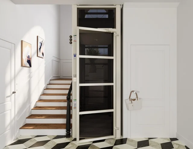 Beige home elevator installed beside a staircase in a bright entryway
