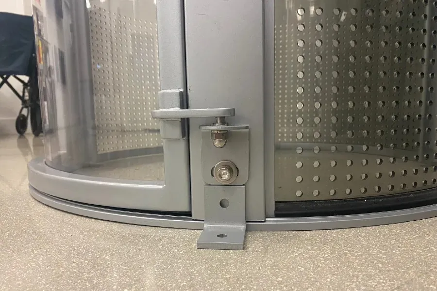Seismic L shaped bracket anchoring a PVE home elevator base to the floor for added stability