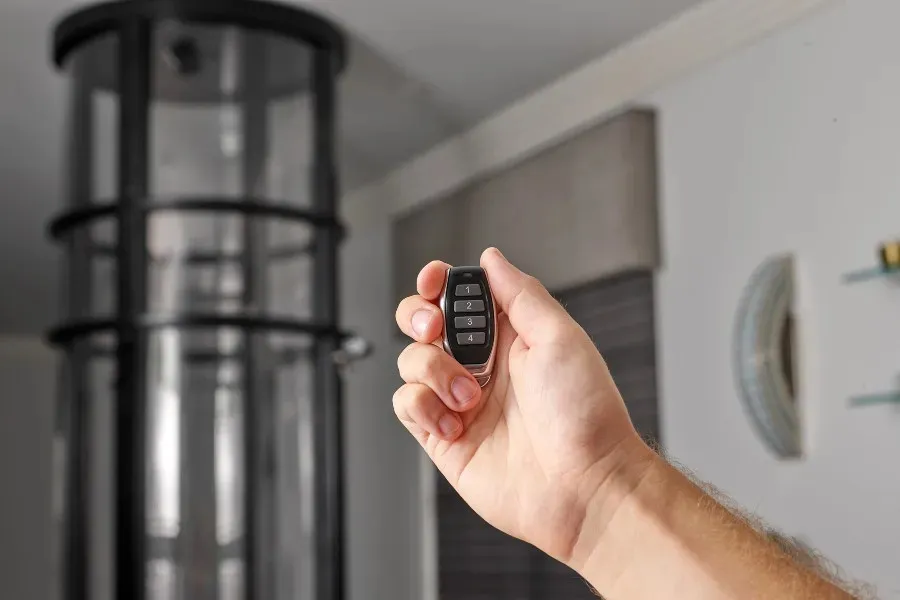 Hand holding a remote control to operate a PVE pneumatic vacuum elevator from a distance